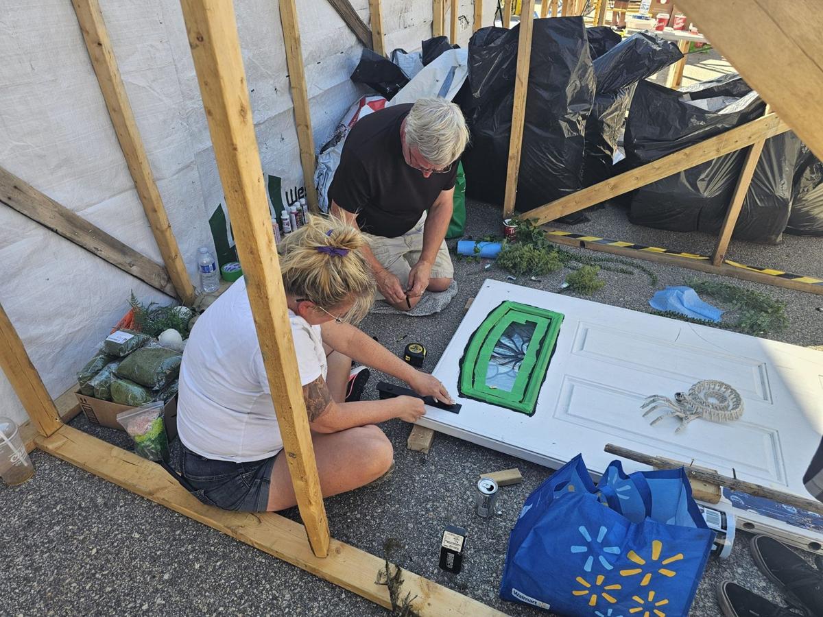 Volunteers painting a prop door inside the build
